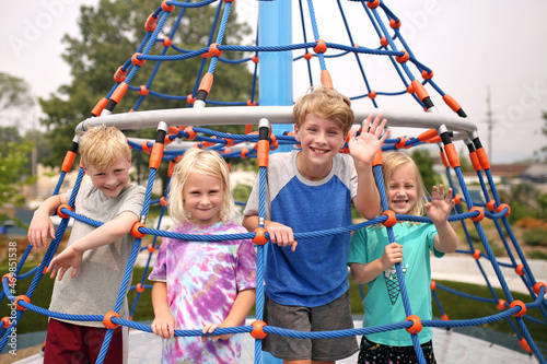 Foto Kids Smiling and Having Fun at Playground on Hot Summer Day