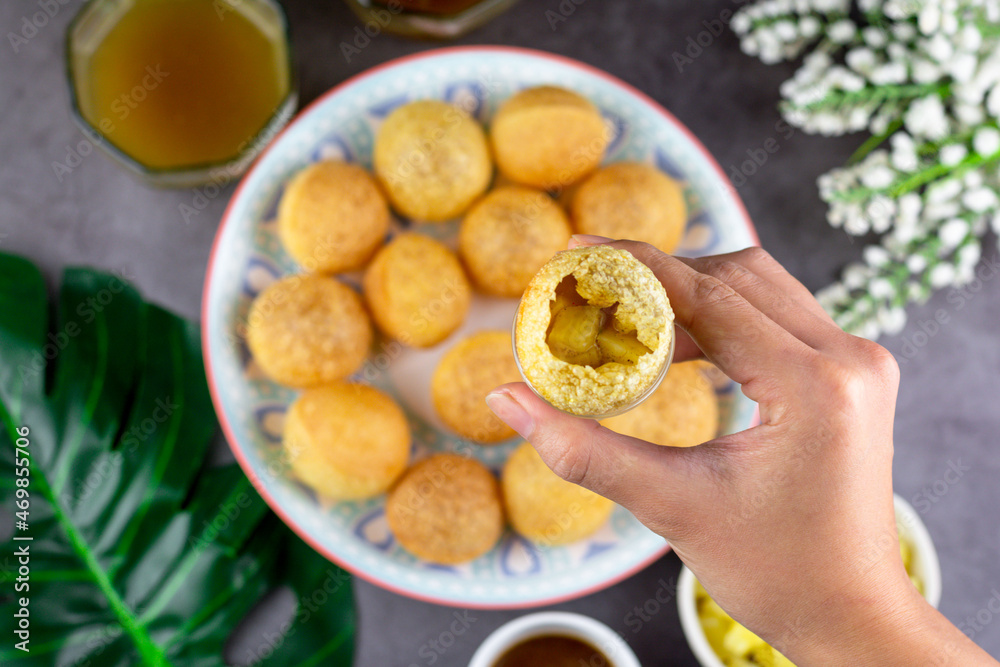 Indian traditional snack. Flat lay hand holding Pani puri with boiled potato and sauce. Indian traditional snack. Flat lay hand holding Pani puri with boiled potato and sauce.