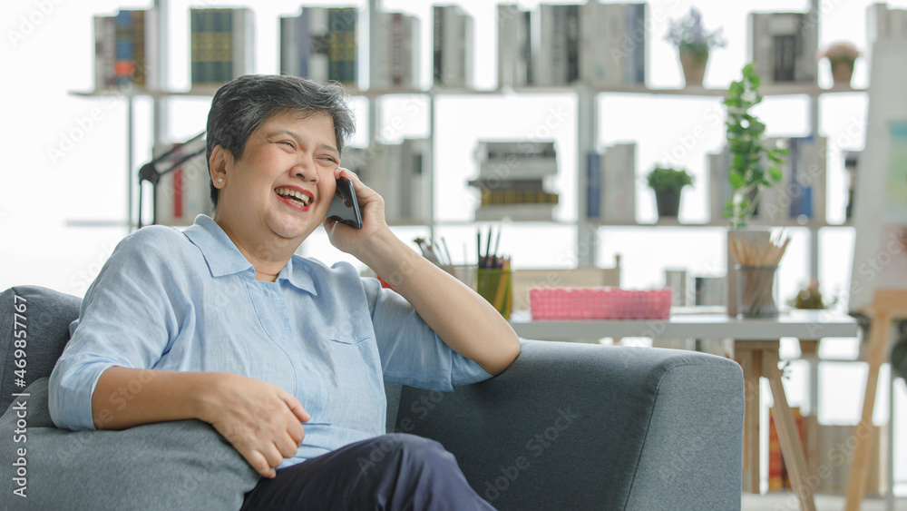Excited Asian woman speaking on cellphone