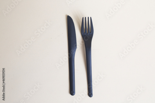 black plastic knife and fork isolated on light background flat lay