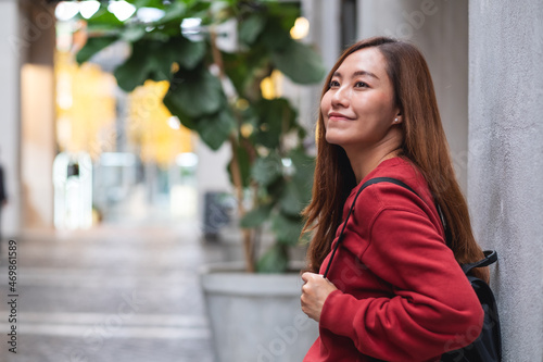 Portrait of a young asian woman walking on the street while traveling and sightseeing around the city