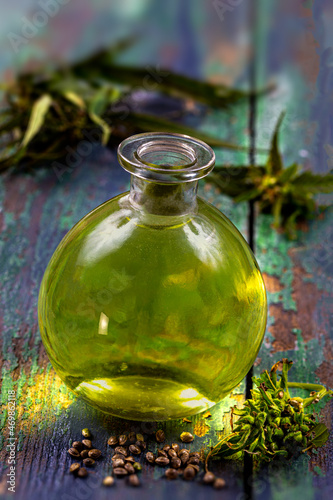 Organic hemp vegetable oil with leaf and seeds wooden background