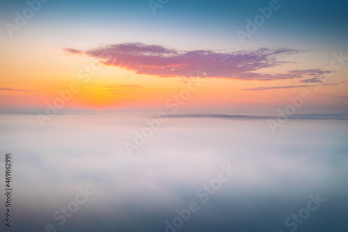 Bird's eye view of the fantastic ocean of clouds at sunrise. Aerial photography, drone shot. © Leonid Tit