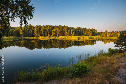 Splendid view of a calm lake and green forests on a sunny day.