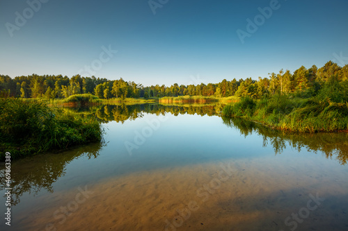 Fototapeta Naklejka Na Ścianę i Meble -  Fantastic view of a calm lake and green forests on a sunny day.