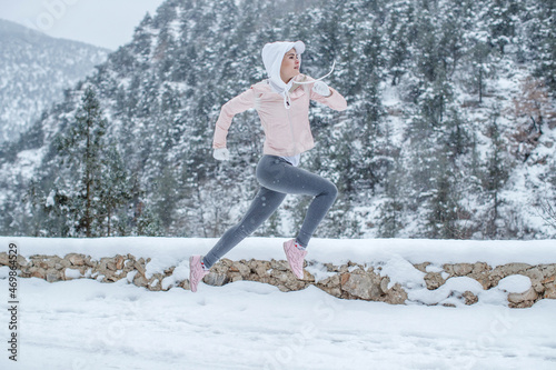 The woman goes in for sports. The girl runs in the winter. High quality photo