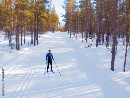 Man cross country skiing on track winter forest tree. Aerial top view