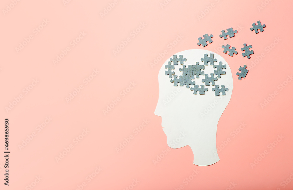 Dementia, alzheimer, memory and mental brain health concept background. Paper head with puzzle pieces on a pink background