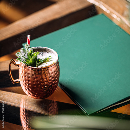 Copper mug of fresh cocktail with mint and powdered sugar photo