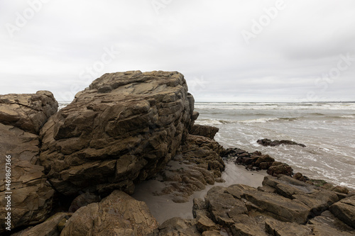 The jagged rocks and coastline of the Atlantic coast at Grotto Beach, a wide beach near Hermanus.  photo