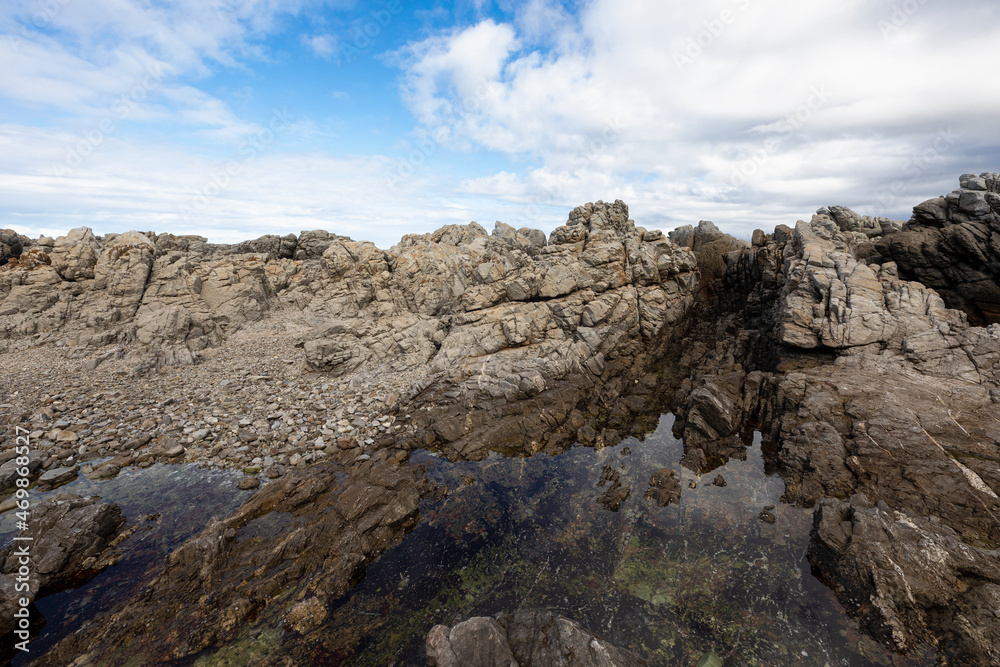 Rocky jagged coastline, eroded sandstone rock, view out to the ocean Rocky jagged coastline, eroded sandstone rock, view out to the ocean
