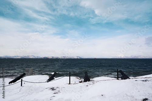 Winter landscape of the Avacha bay. Four old cannons and stormy ocean.