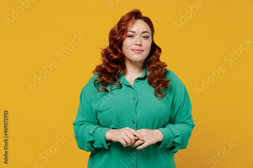 Foto Charming bright happy young ginger chubby overweight woman 20s years old wear green shirt looking camera smiling isolated on plain yellow background studio portrait