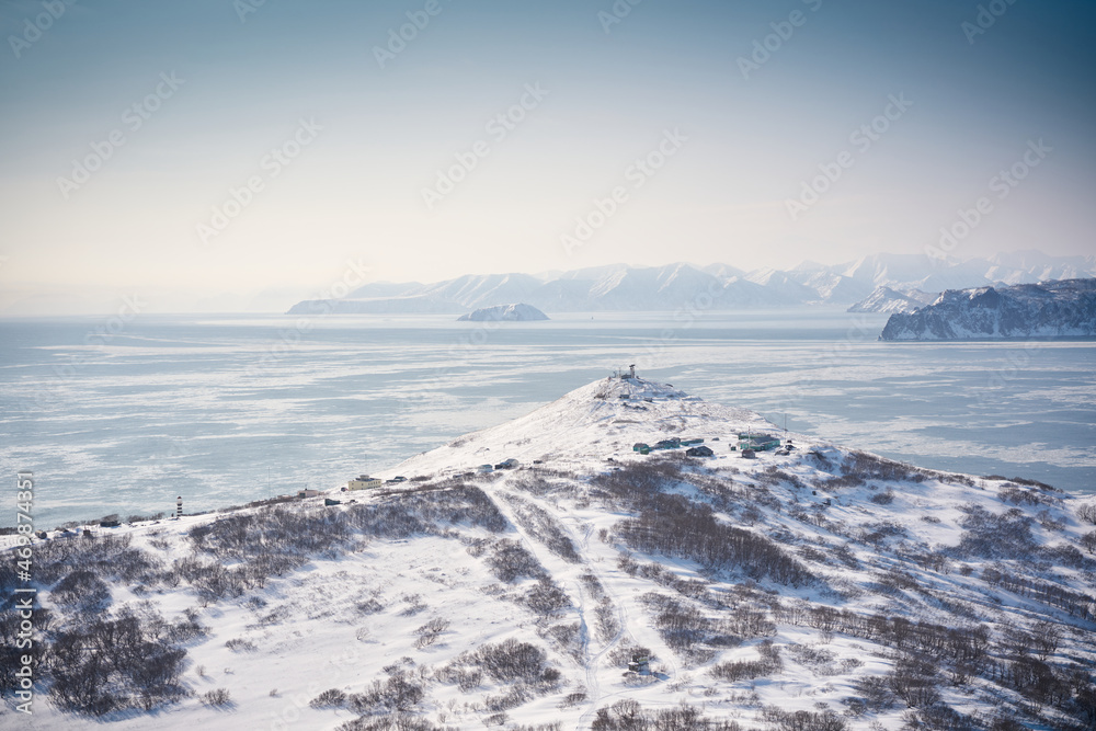 Winter landscape of the Avacha bay. Snowy mountains and blue ocean. Kamchatka peninsula, Russia