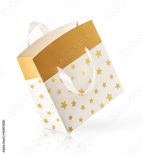 Golden paper gift bag isolated on white background.