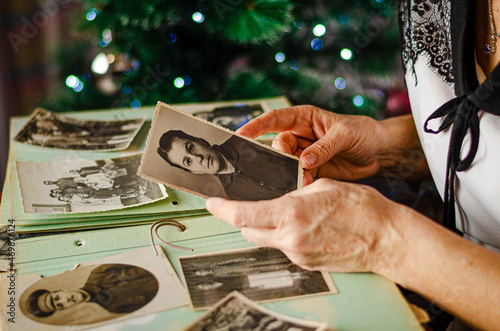 Принти на полотні Cherkasy/Ukraine- December 12, 2019: Female hands holding a photo of her mother on christmas tree background