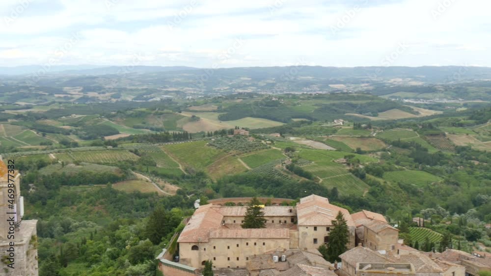 San Gimignano, Siena, Tuscany, Italy JULY, 14, 2016 Rooftops of San Gimignano from tower top with surrounding green hills San Gimignano, Siena, Tuscany, Italy JULY, 14, 2016 Rooftops of San Gimignano from tower top with surrounding green hills