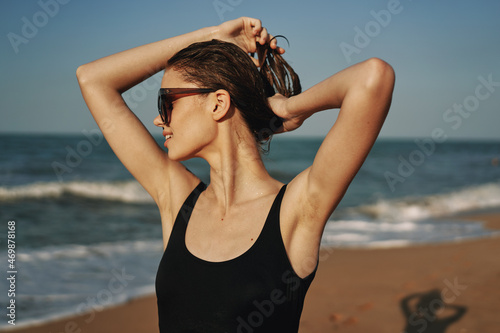 cheerful woman in black swimsuit sunglasses beach walk travel