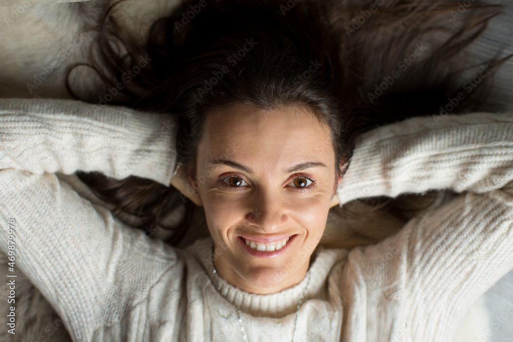 Middle aged woman, lying on the ground in a wooden cabin, smiling Middle aged woman, lying on the ground in a wooden cabin, smiling