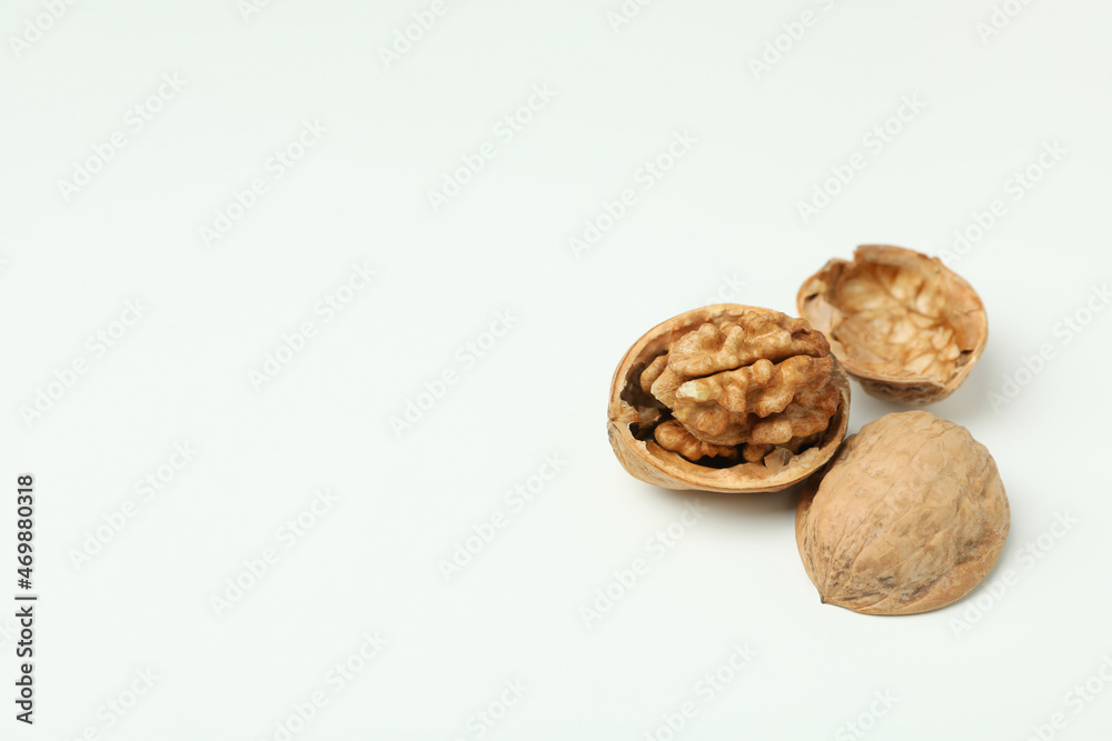 Walnuts with nutshell on white background, close up Walnuts with nutshell on white background, close up
