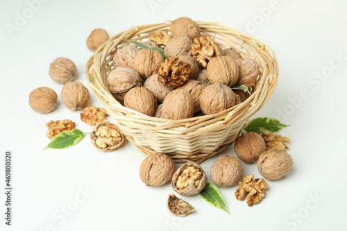 Walnuts in wicker bowl on white background photo