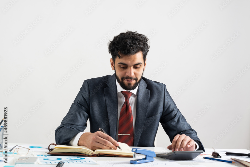 Businessman in suit and tie standing near desk Businessman in suit and tie standing near desk