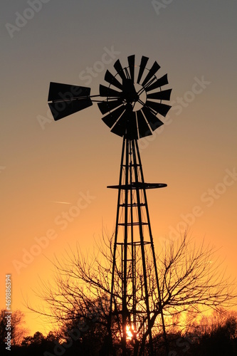 windmill at sunset with a colorful sky north of Hutchinson Kansas USA out in the country.