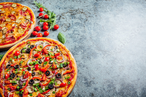 Top dow flat lay view on pizzas with fresh eco ingridients on rustic background, Pizza shop table photo