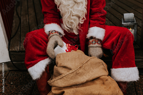 Person wearing Santa costume holding Christmas present photo