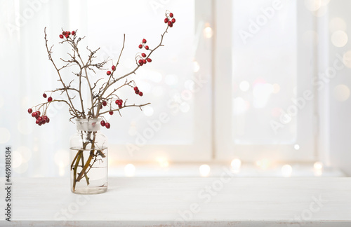 Winter holiday composition with branches of red berries in vase