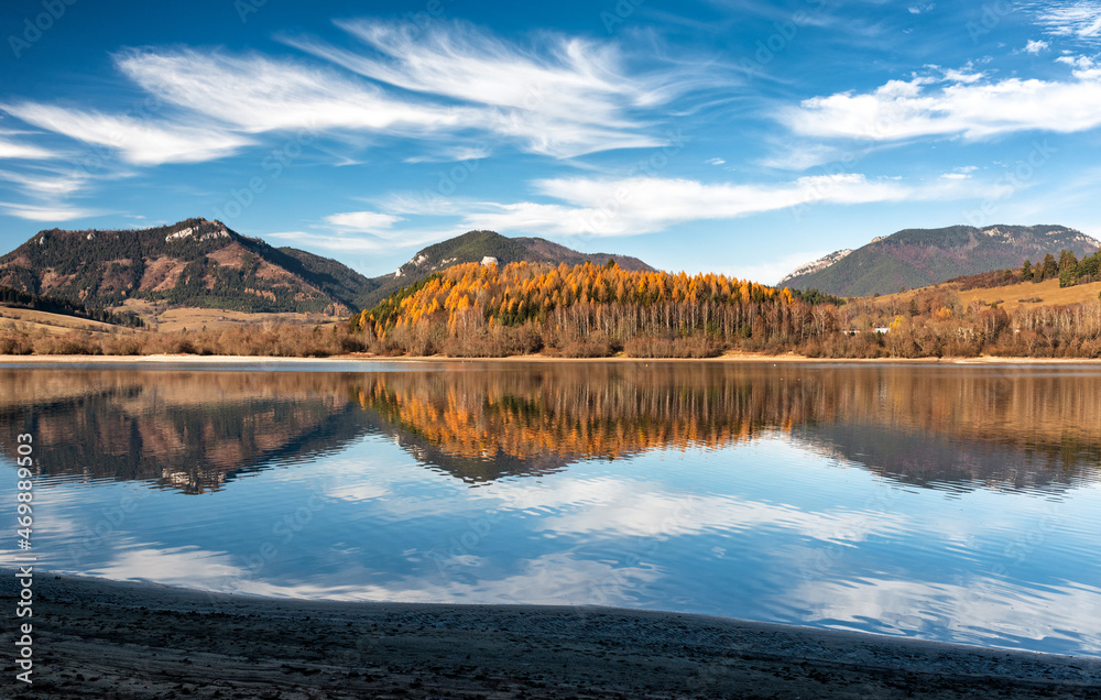 Reflection of autumn trees and hills on water surface. Dam Liptovska Mara at Slovakia