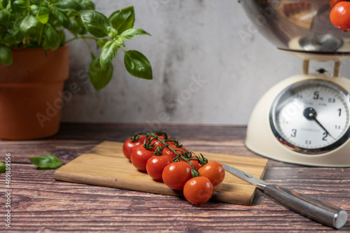Obraz na plátně A panicle cocktail tomato lies on a cutting board