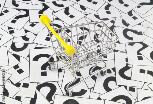 Shopping cart on question marks background. Shopping FAQ concept.