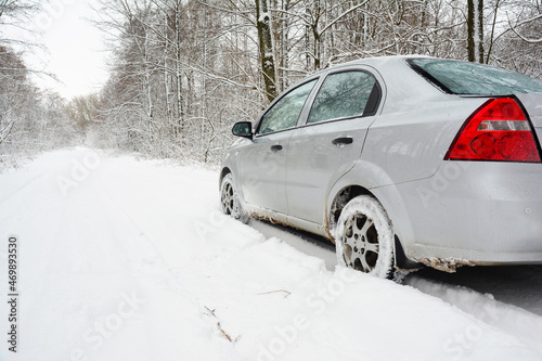 Driving a sedan car in deep snow. Driving a gray sedan car through a snowy winter forest. Driving home for Christmas.