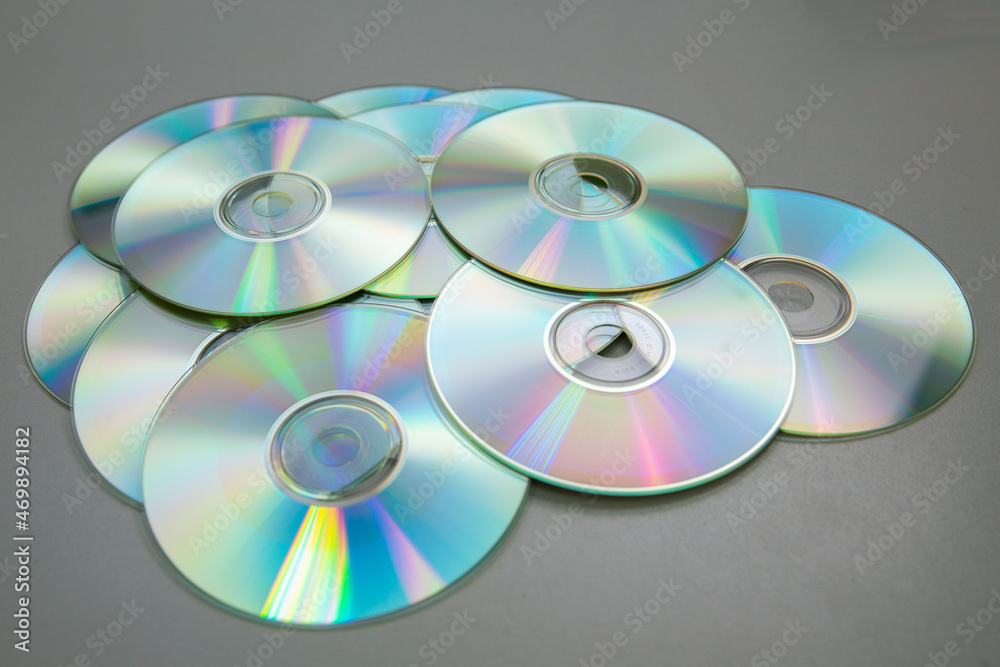 Lots of CDs DVDs on a gray background. Lots of CDs DVDs on a gray background.