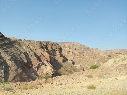 R  gion de hautes montagnes rocheuses  zone d  sertique et de la roche blanche ou rouge  circulation sur les flancs de la montagne  avec falaise  forte chaleur et ciel bleu  en Jordanie. 