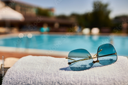 Beautiful sunglasses on the background of the pool. Relax by the pool. Sunglasses.