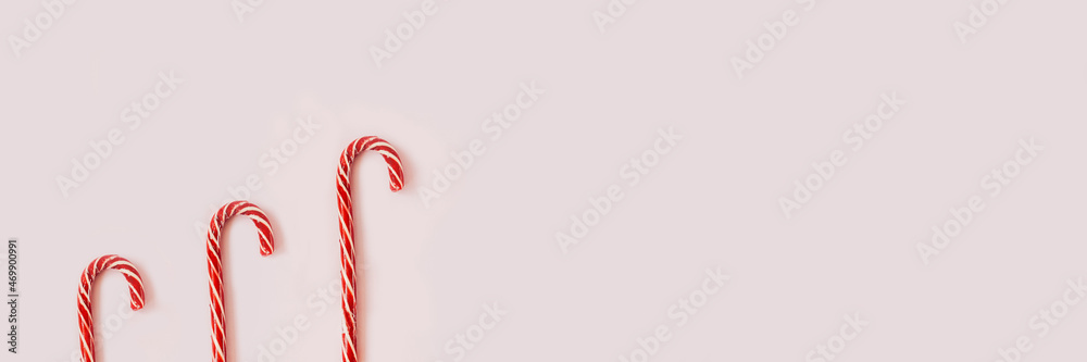 Fototapeta premium Christmas candy canes on pink background above.