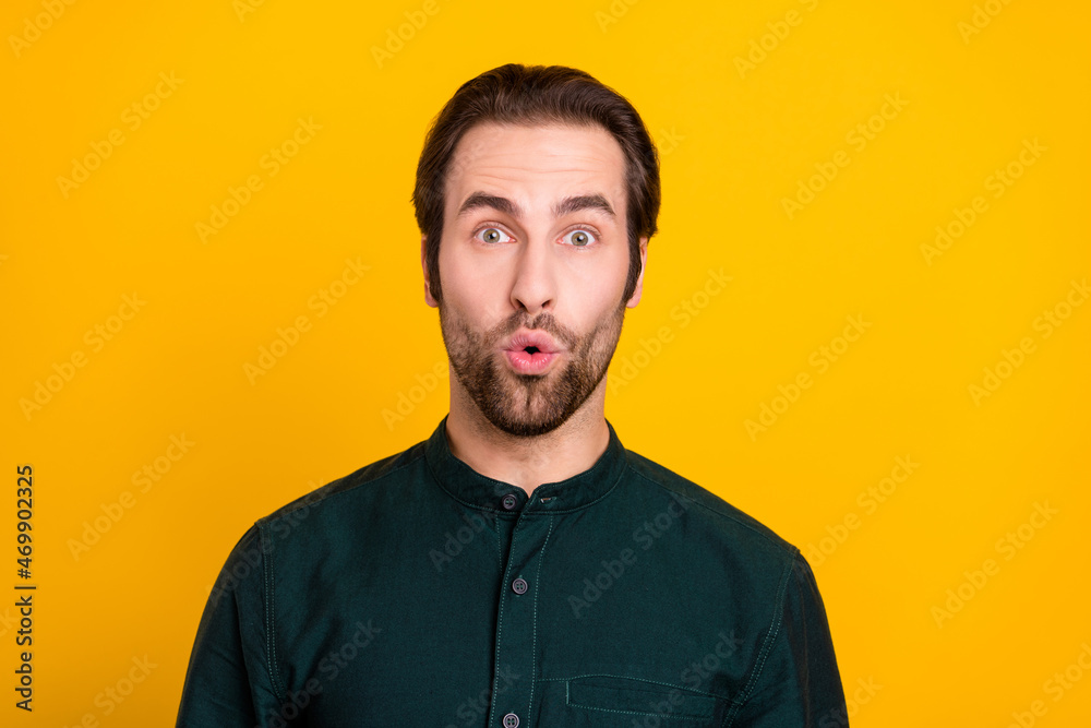 Photo of impressed young guy look wear green shirt isolated on yellow color background Photo of impressed young guy look wear green shirt isolated on yellow color background