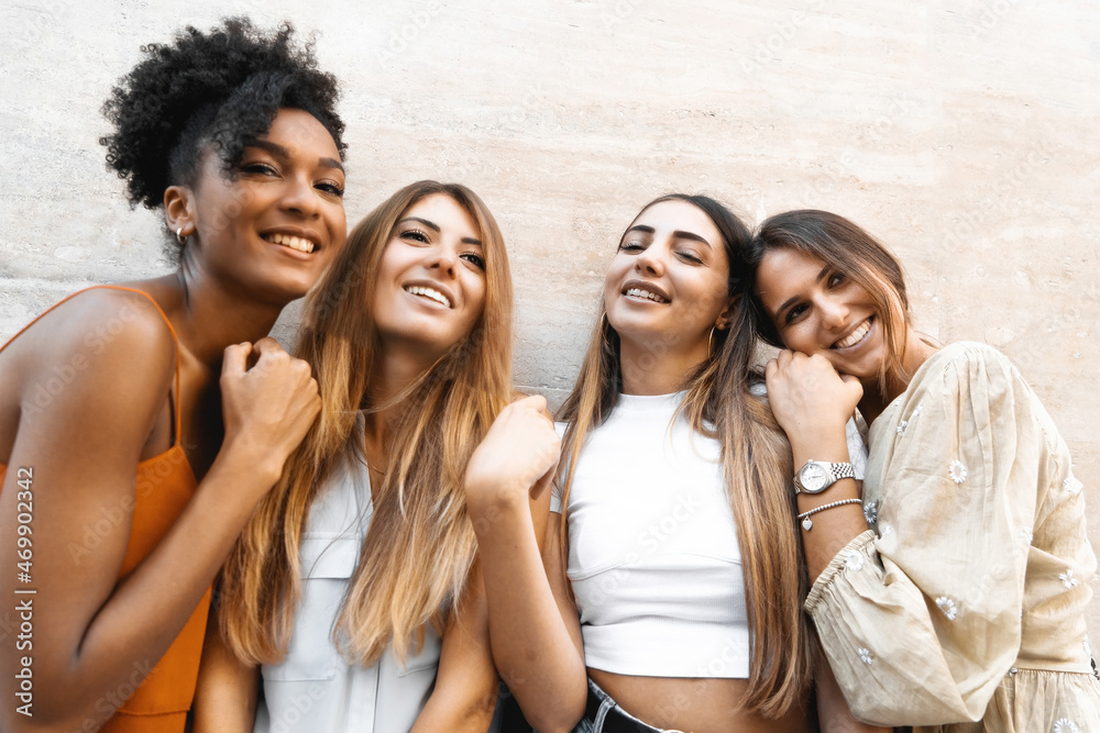 Obraz premium Joyful Girlfriends Having Fun Standing Against a Wall - A Group of Cheerful young Women Gather Carefree