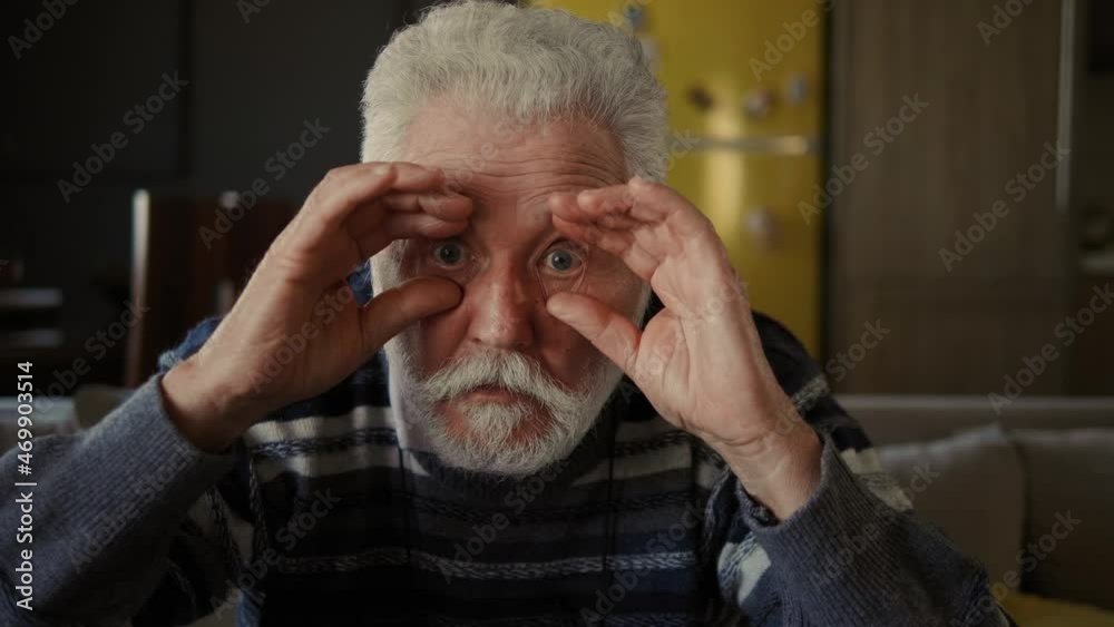 Close up portrait of elderly man , peering to camera, feeling troubles with vision. Old person eyesight problems. Senior man staring at camera and holding glasses Close up portrait of elderly man , peering to camera, feeling troubles with vision. Old person eyesight problems. Senior man staring at camera and holding glasses
