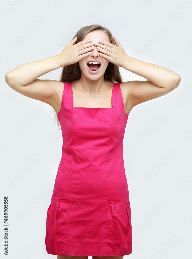 Portrait of young woman covering her face with hands.Girl peeking through fingers Portrait of young woman covering her face with hands.Girl peeking through fingers