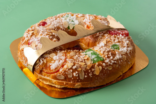 Spanish typical epiphany cake "Roscon de Reyes" on green background