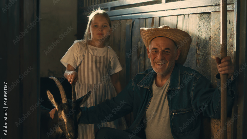 Grandfather and granddaughter with goat