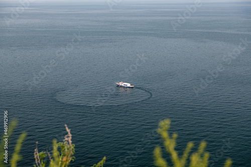 The yacht is turning around on Lake Baikal near the Cape Khoboy. Olkhon Island, Russia. photo