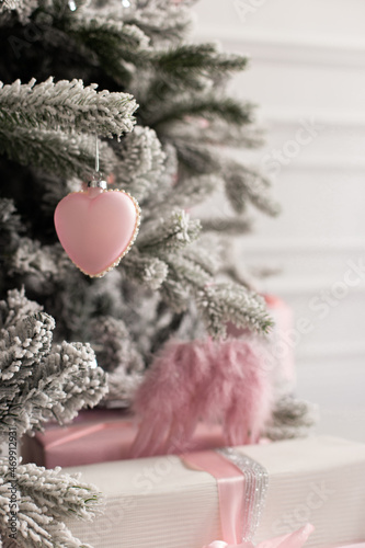 Christmas tree with toys vovered in snow. New Year composition with spruce and lights. Close up image of christmass tree photo