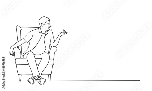 Young man sits in a chair and talks.