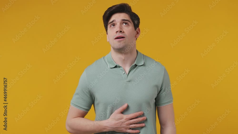 Sick ill sad tired nervous sad young man 20s years old wears blue t-shirt put hands on abdomen suffering from stomach-ache griping bellyache feel bad seedy isolated on plain yellow background studio Sick ill sad tired nervous sad young man 20s years old wears blue t-shirt put hands on abdomen suffering from stomach-ache griping bellyache feel bad seedy isolated on plain yellow background studio