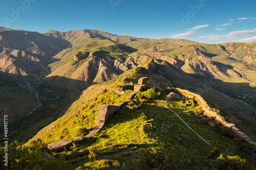 Panoramic view of the famous Smbataberd fortress in the Armenian Transcaucasia with gorgeous views of mountain valleys at golden sunset light