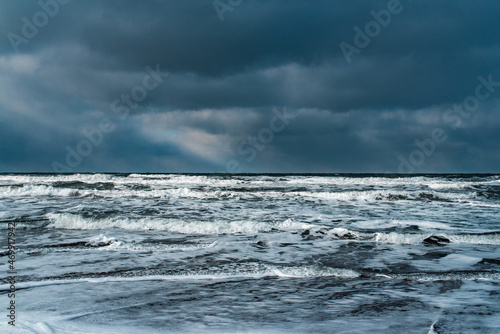 Winter landscape with frozen sea and icy beach. Storm and snow weather. Dramatic seascape.